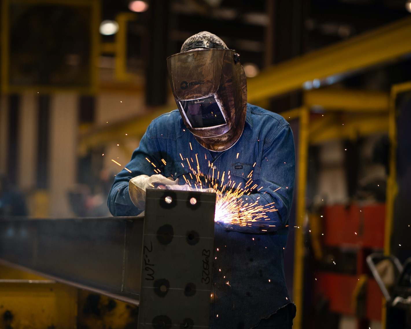 Employee welding a piece of metal